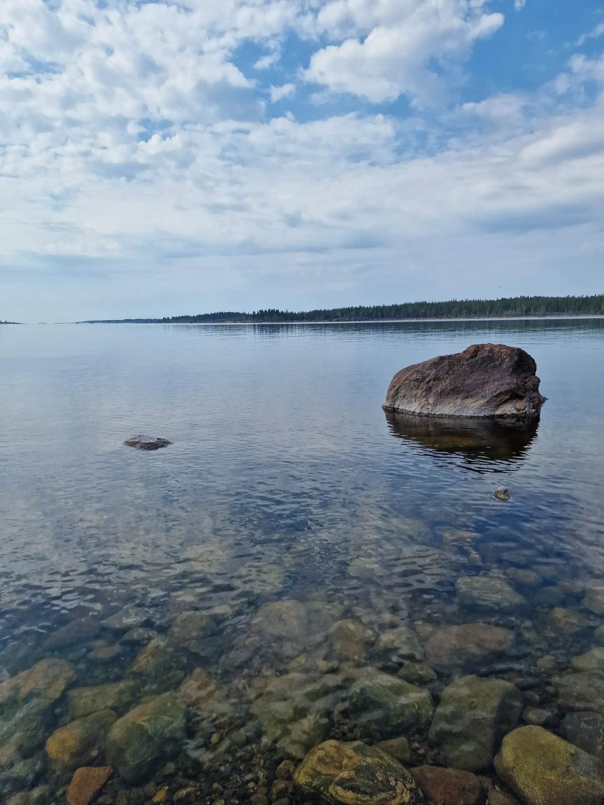 Clear sea with underwater stones and a large rock